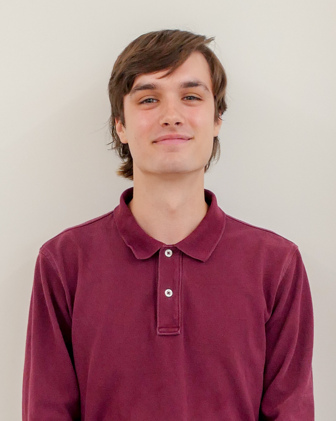 Headshot of Andrew Cosgrove, a smiling man with brown hair and a red shirt