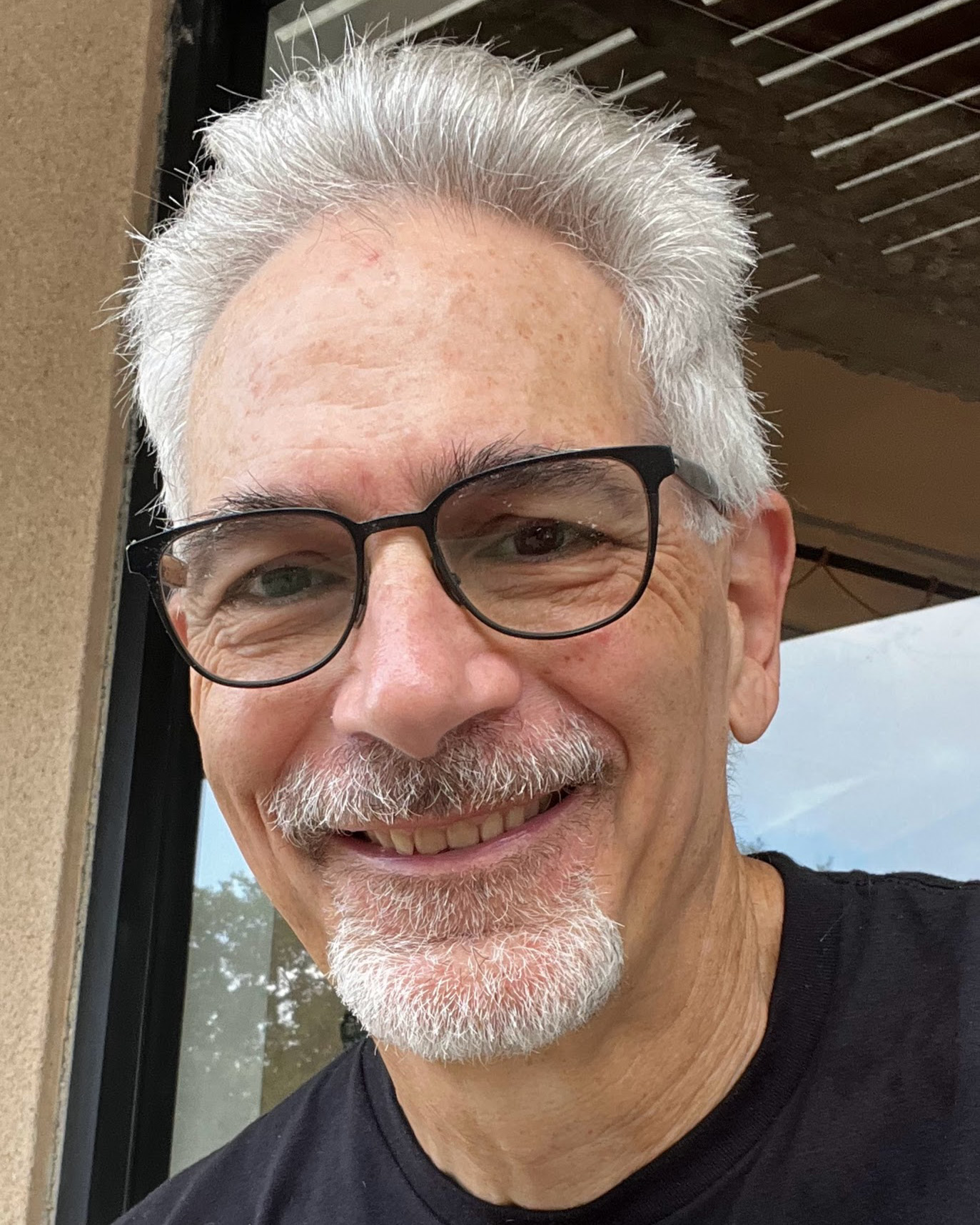 Headshot of Bob Gleichauf, a man smiling wearing black glasses and a black shirt