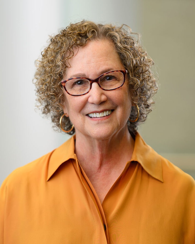 Headshot of Felice Frankel, a woman smiling wearing glasses and an orange shirt