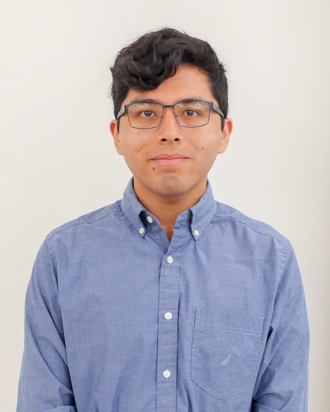 Headshot of Ian Valle, wearing glasses and a blue shirt
