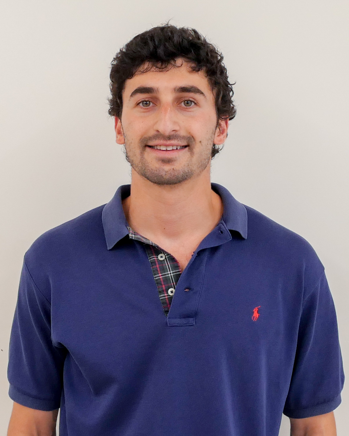 Headshot of Jacob Safeer, smiling and wearing an indigo polo