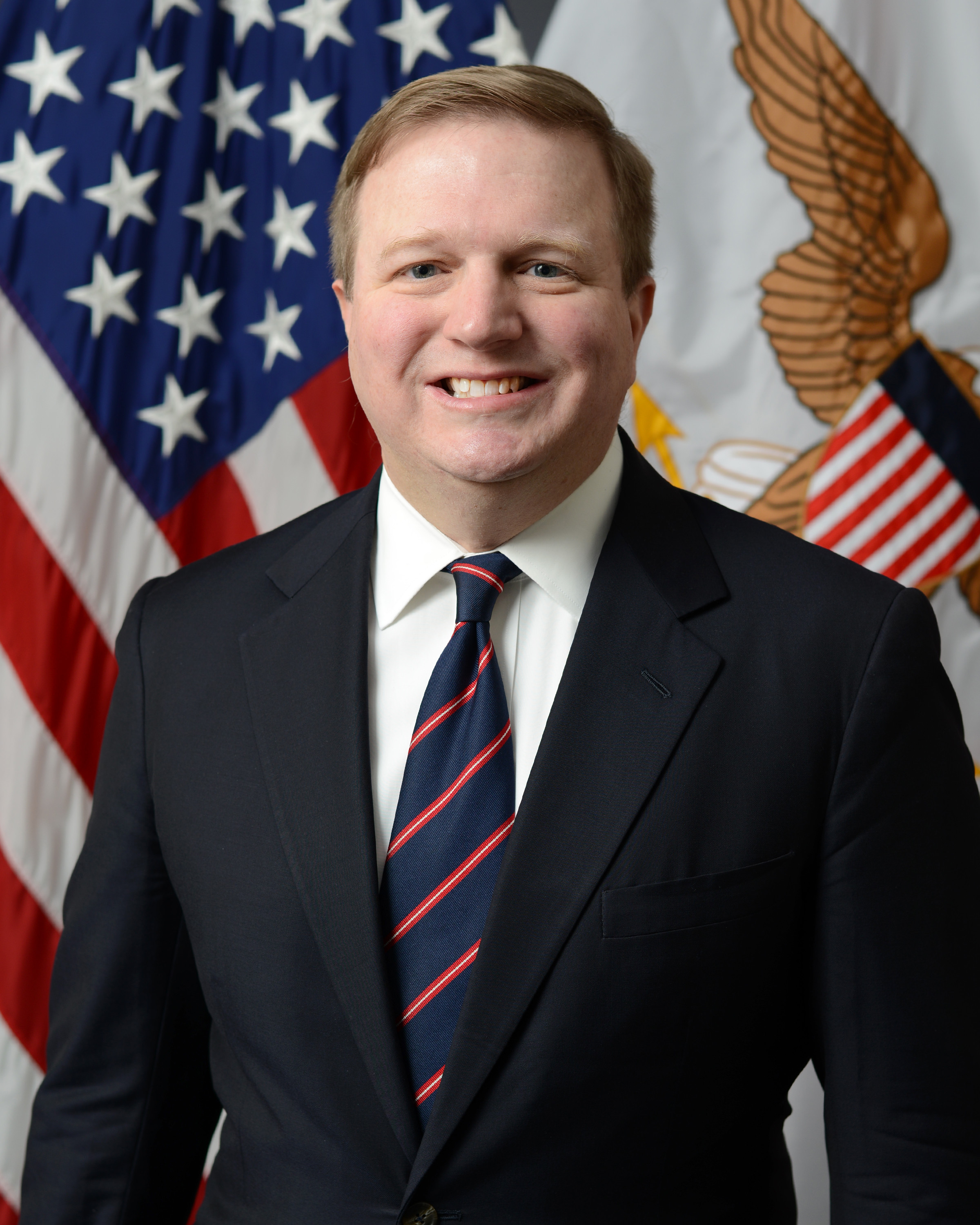 Headshot of Joseph S Jewell, a smiling man wearing a striped tie and dark jacket