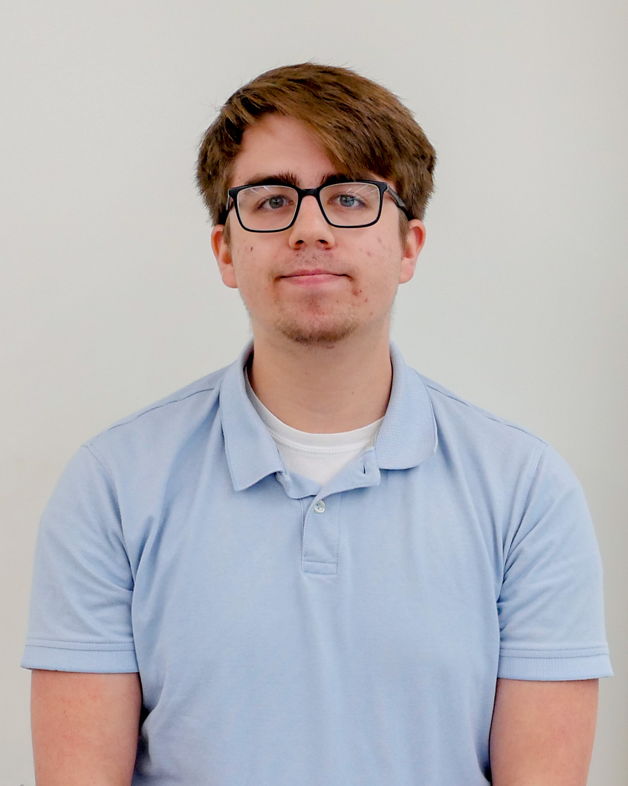 Headshot of Lucas Wendland, wearing glasses and a light blue polo