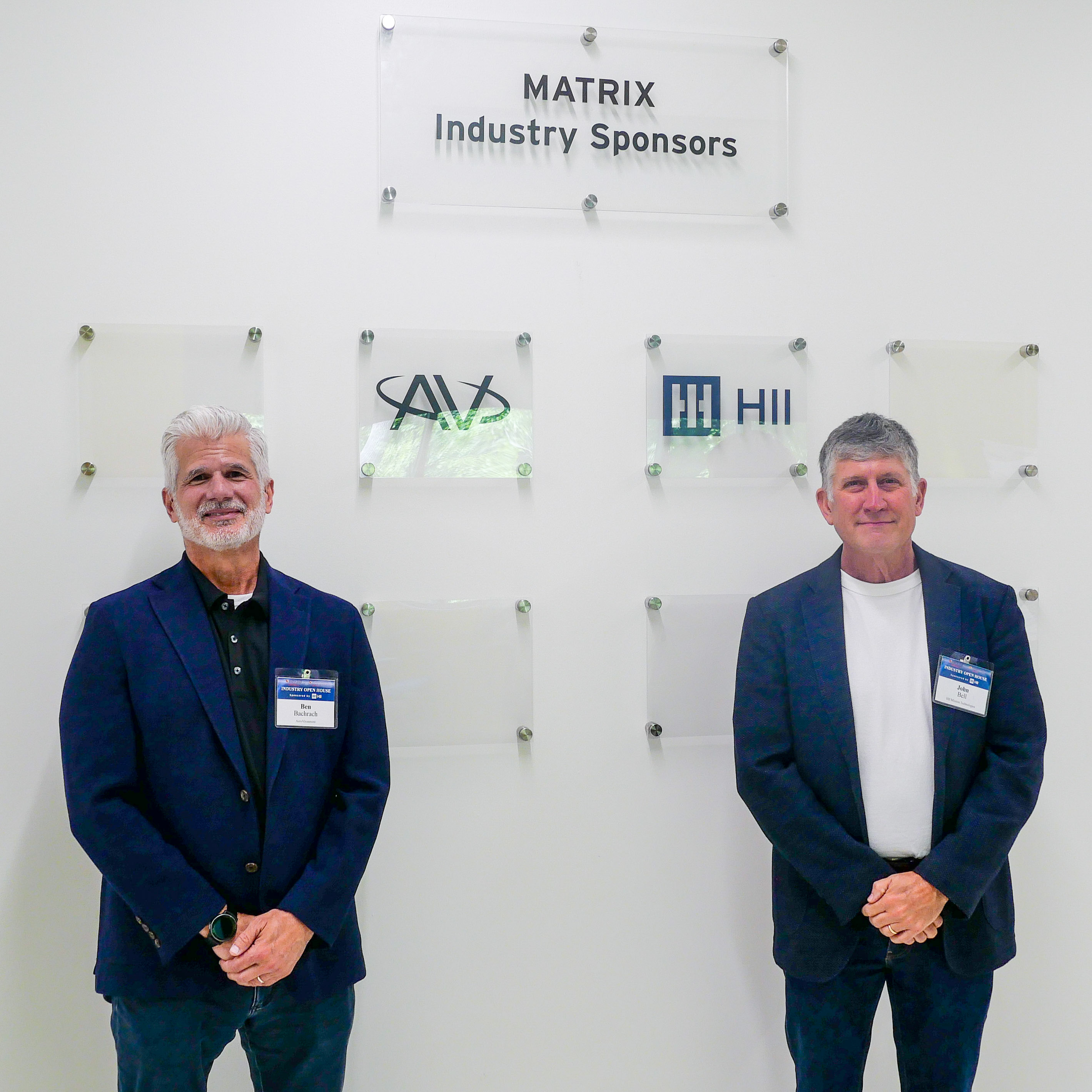 Two men stand in front of logo wall that reads "MATRIX Industry Sponsors"