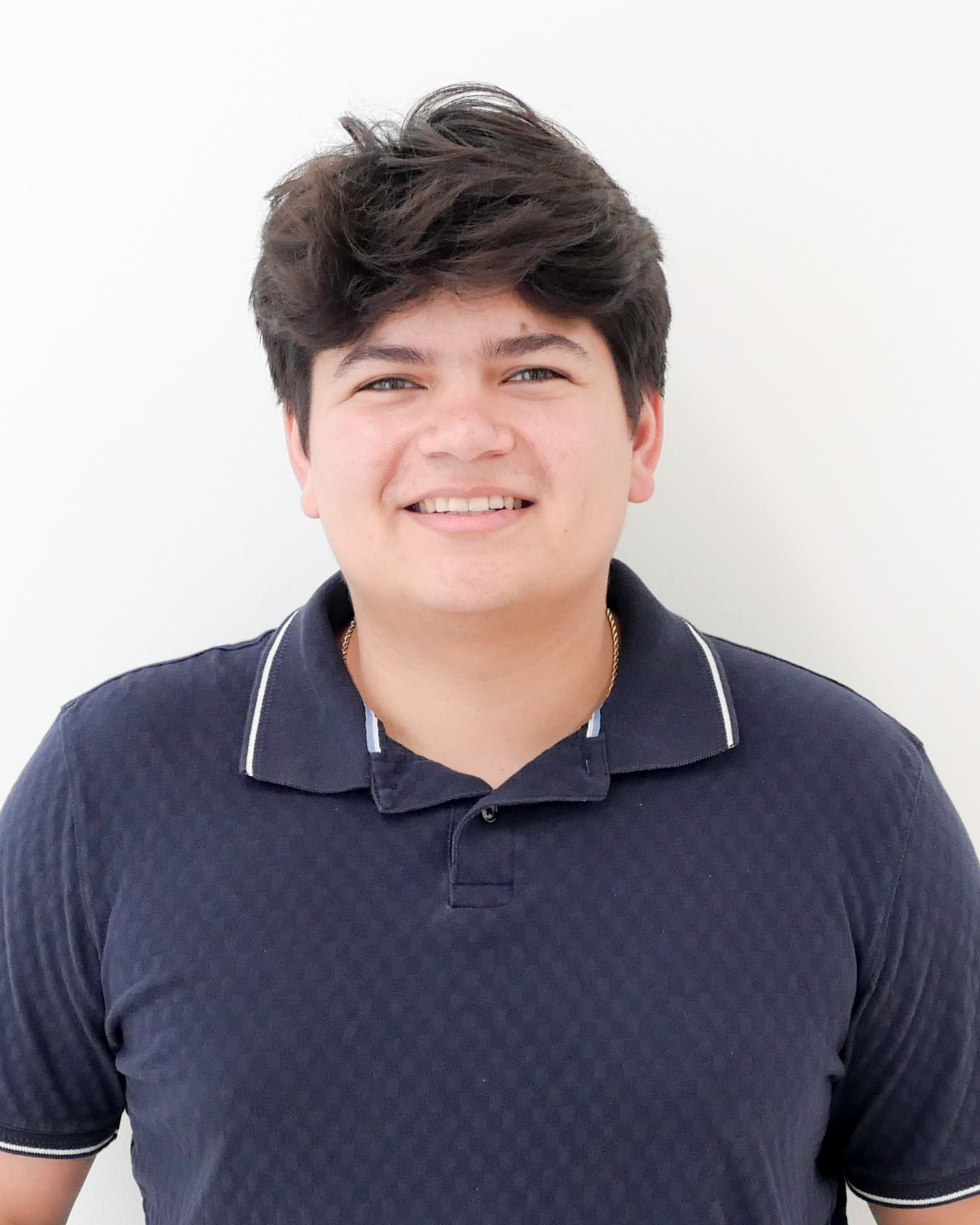 Headshot of Oscar Ruiz, a man smiling wearing a dark blue polo