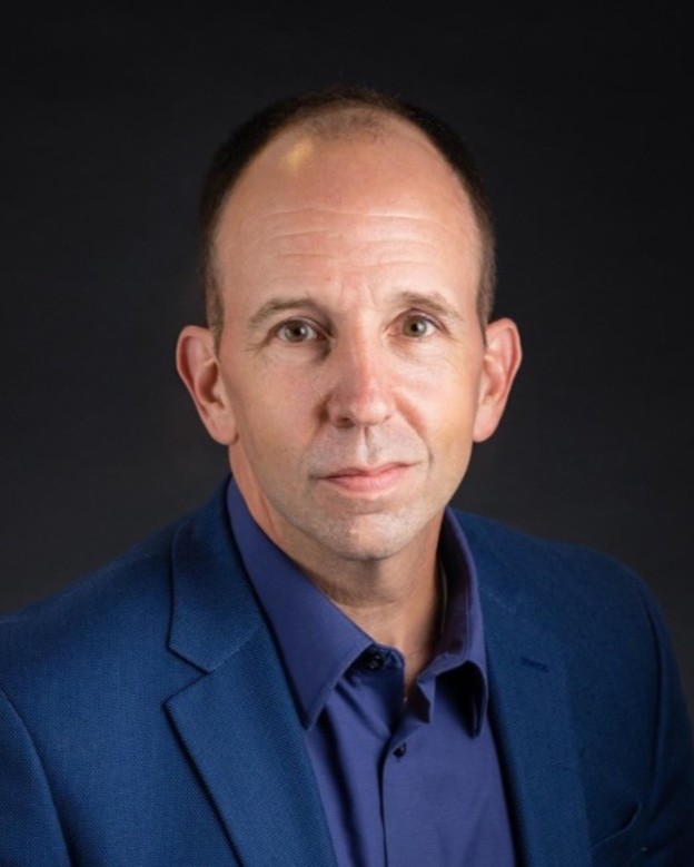 Headshot of Rob Cohen, a man smiling and wearing a blue jacket and shirt