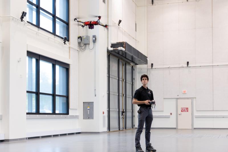 Pilot flies drone in open lab space