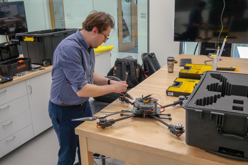 Man holding a screwdriver assembling a drone