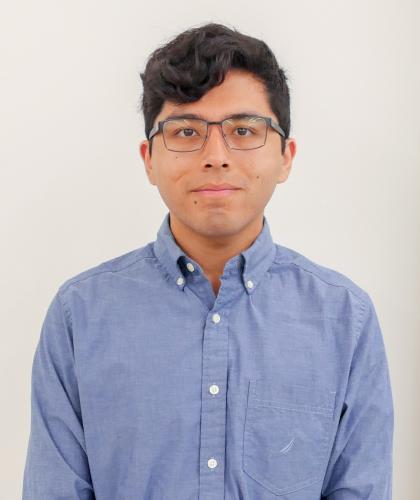 Headshot of Ian Valle, wearing glasses and a blue shirt