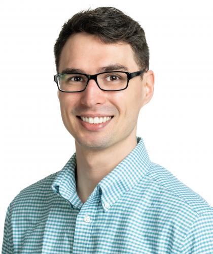Headshot of Jamison Watson, a man with dark hair wearing glasses and a blue collared shirt