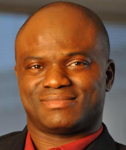 Headshot of Kingsley Fregene, a man smiling and wearing a red shirt