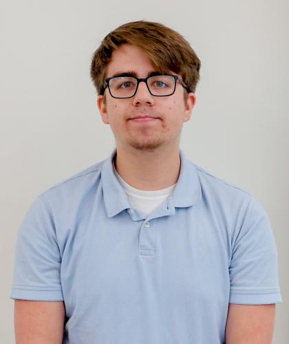 Headshot of Lucas Wendland, wearing glasses and a light blue polo