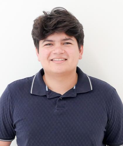 Headshot of Oscar Ruiz, a man smiling wearing a dark blue polo